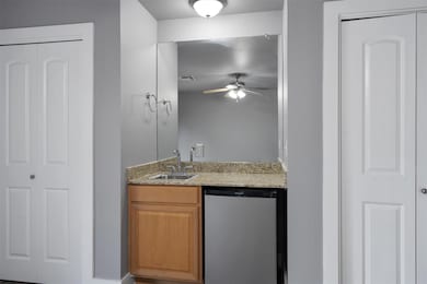 Bar with a ceiling fan, a sink, dishwasher, indoo