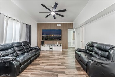 Living room with an accent wall, a ceiling fan, wo