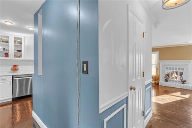 Hall with dark wood-type flooring and crown molding