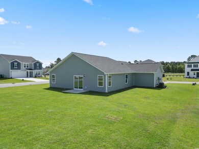 Rear view of property featuring a garage and a law