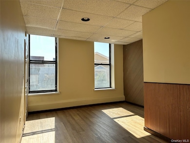 Bedroom #1 featuring wood walls, a drop ceiling, and wood finished floors