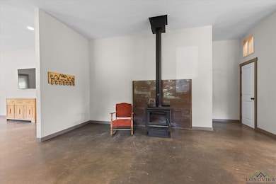 Sitting room with concrete flooring and a wood stove
