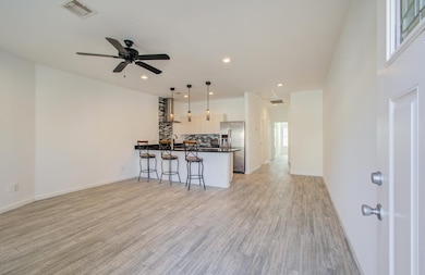 Another view of the modern, open concept living space with a stylish kitchen featuring stainless steel appliances.