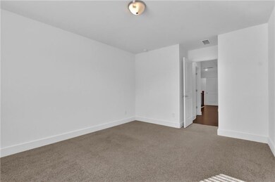 Carpeted spare room with baseboards and visible ve