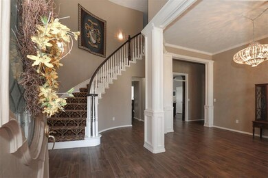 Foyer featuring dark wood-type flooring, a chandel