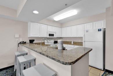 Kitchen with white cabinets, recessed lighting, wh