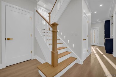 Stairway featuring wood finished floors, recessed lighting, and ornamental molding