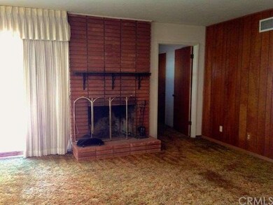 Brick fireplace, well-cared for paneling in the li