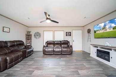 Living area featuring ceiling fan, crown molding, 