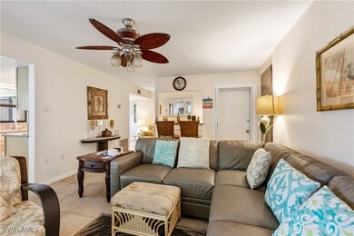 Living room featuring a ceiling fan, light tile pa