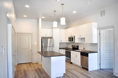 Kitchen featuring dark countertops, a sink, stainl