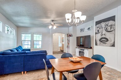 Dining space featuring arched walkways, a textured ceiling, a chandelier, and a ceiling fan