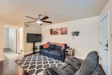 Living area featuring baseboards, a ceiling fan, 