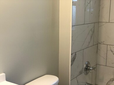 Bathroom with toilet and tiled shower