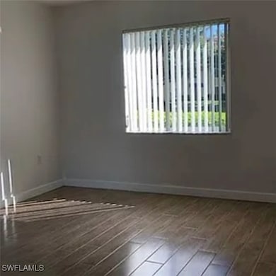 Unfurnished room featuring healthy amount of natural light and wood finished floors