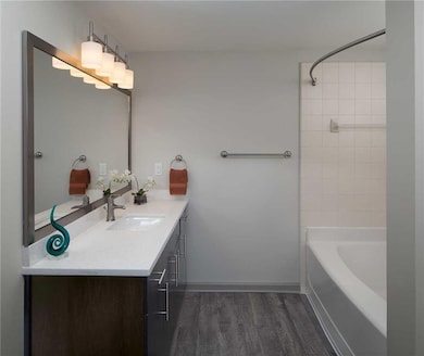 Bathroom with tiled shower / bath combo, wood-type