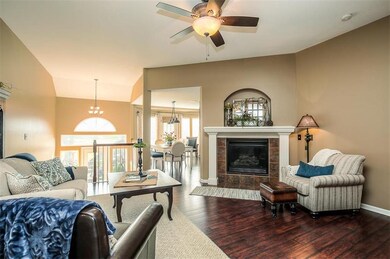 Great room with fireplace and ceiling fan. Steps t