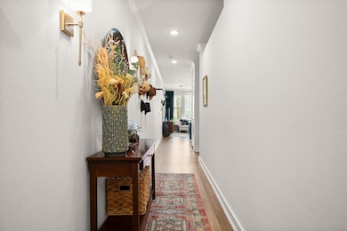 Hallway with wood finished floors and recessed li