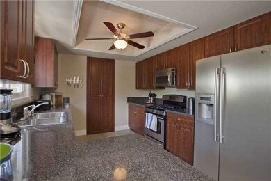 A no bones and very functioning kitchen with easy wipe surfaces and cherry stained cabinets. window over sink to outside entertainment patio