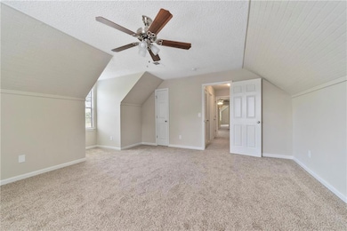 Bonus room with light colored carpet, lofted ceili