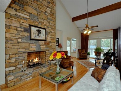 Living room with stone fireplace and vaulted beame