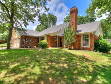 Ranch-style home featuring brick siding, a chimney, a garage, and a front lawn