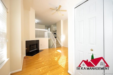 Unfurnished living room featuring light wood finished floors, a fireplace, stairs, and a ceiling fan