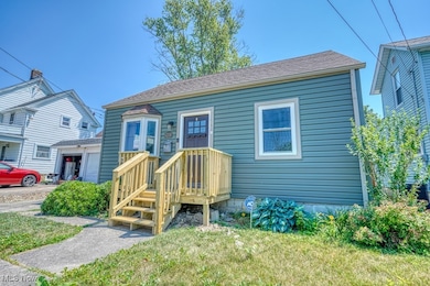 View of front facade featuring roof with shingles and a front yard