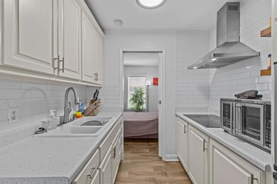 Kitchen with white cabinetry, black electric cook
