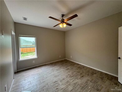Unfurnished room with a ceiling fan, wood finished floors, and baseboards