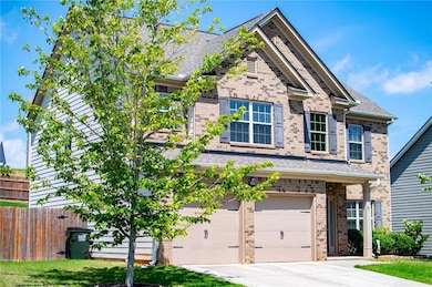 View of front of house with brick siding, an attached garage, driveway, and roof with shingles