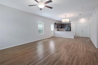 Unfurnished living room with dark wood-style floo