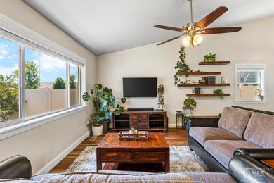 Living room with lofted ceiling, a ceiling fan, and wood finished floors
