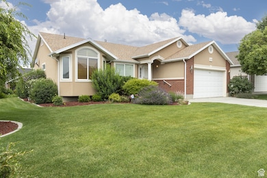 Single story home with brick siding, a front lawn, and driveway