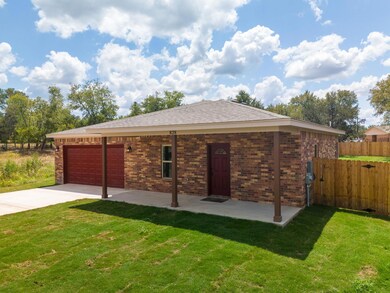Rear view of property featuring a yard, brick sid