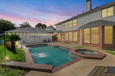 Spacious backyard with a pool and spa, accented by