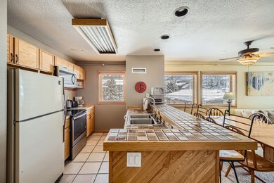 Kitchen with light tile patterned flooring, stainl