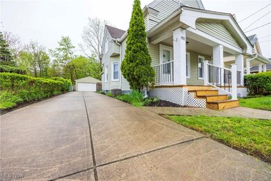 View of property exterior featuring covered porch, a garage, and an outbuilding
