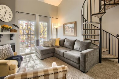 Living room with stairs, light carpet, and a high ceiling