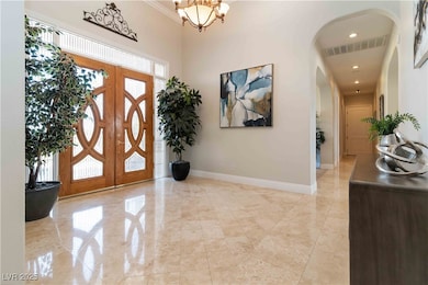 Foyer entrance featuring a chandelier, recessed lighting, and arched walkways