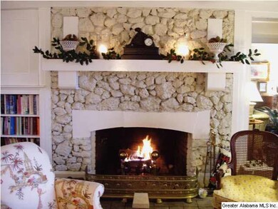 Wood burning fireplace flanked by built-in bookcas