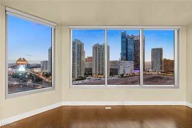 The living room features large windows with an unobstructed view of the iconic Las Vegas Strip.