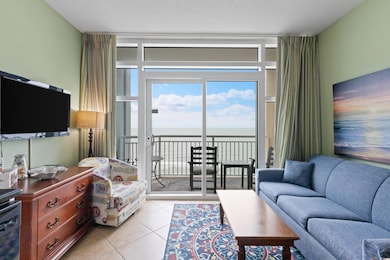 Living room with a water view, light tile patterned floors, and a textured ceiling