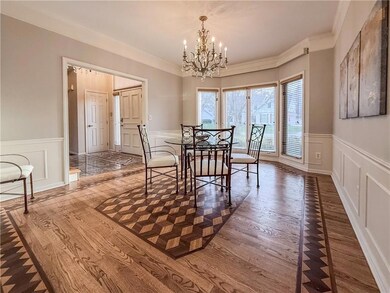 Dining room with crown molding, hardwood / wood-style floors, and a chandelier