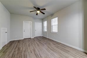 Spare room with a ceiling fan, baseboards, and wo