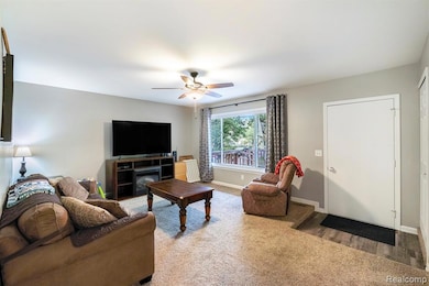 Living area featuring carpet floors and ceiling fan