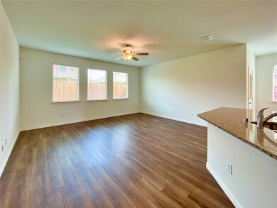 Unfurnished living room with ceiling fan and dark hardwood / wood-style flooring