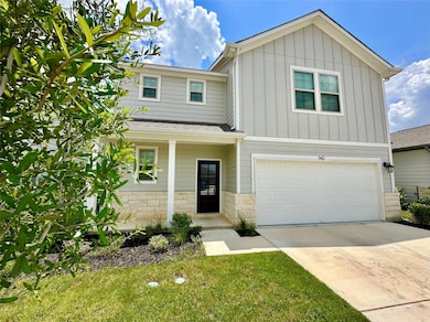 View of front of house with a garage, board and b