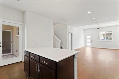 Kitchen featuring wood finished floors, light cou
