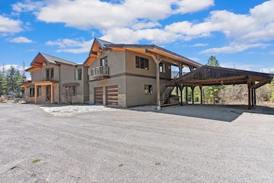 View of side of home featuring stucco siding, stone siding, a garage, and stairway